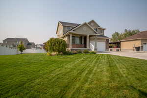 View of front of property featuring a garage and a front lawn