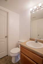 Bathroom with vanity, toilet, and tile patterned flooring