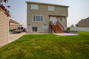 Rear view of house featuring french doors, a yard, a hot tub, and a patio