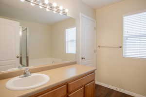 Bathroom featuring vanity, wood-type flooring, and a healthy amount of sunlight