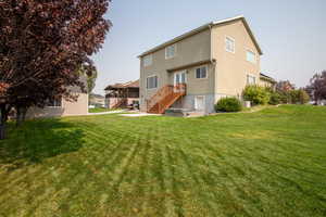 Rear view of property with cooling unit and a yard