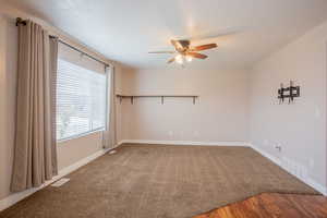 Carpeted empty room with ceiling fan