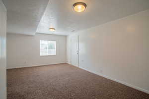 Carpeted spare room with a textured ceiling