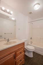 Full bathroom with toilet, vanity, tile patterned floors, and  shower combination