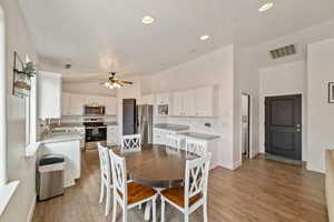 Dining area featuring hardwood / wood-style flooring, ceiling fan, lofted ceiling, and sink