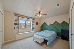 Carpeted bedroom with a closet and ceiling fan