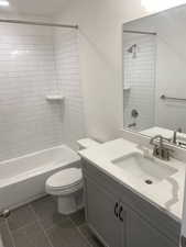 Full bathroom featuring tiled shower / bath, vanity, and toilet