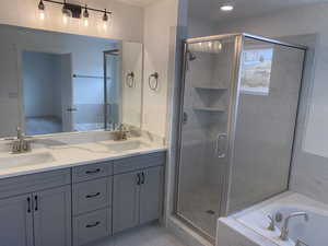 Bathroom featuring vanity and shower with separate bathtub