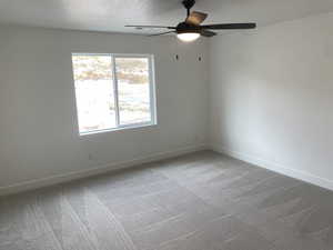 Bedroom with ceiling fan, and light colored carpet