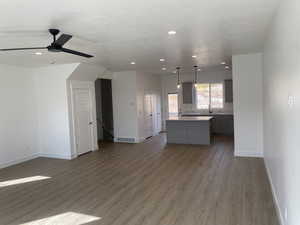 Kitchen featuring decorative light fixtures, gray cabinetry, dark hardwood / wood-style flooring, a center island, and a textured ceiling