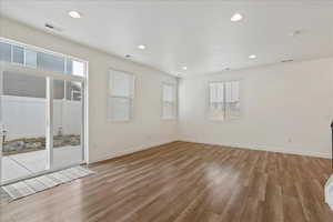 Unfurnished room with hardwood / wood-style flooring and a textured ceiling