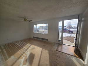 Entrance foyer featuring a baseboard heating unit, a textured ceiling, and ceiling fan