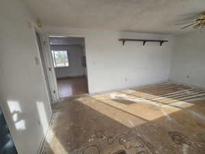 Unfurnished room featuring ceiling fan and a textured ceiling