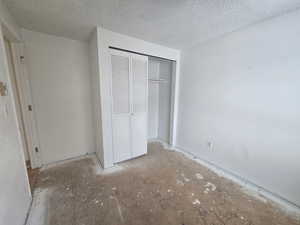 Unfurnished bedroom featuring a closet and a textured ceiling