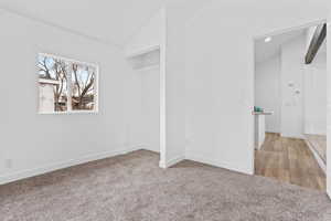 Interior space with lofted ceiling and light carpet