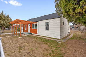 View of front of property featuring a pergola and a front yard