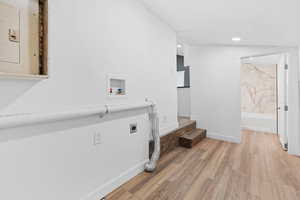 Laundry room with electric dryer hookup, hookup for a washing machine, and wood-type flooring