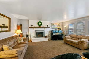 Living room featuring a brick fireplace and carpet floors