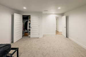 Bedroom featuring light carpet and a closet