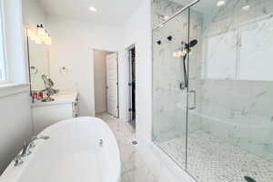 Bathroom featuring vanity and shower with separate bathtub