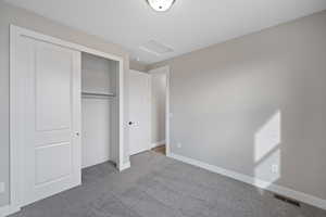 Unfurnished bedroom with carpet and a closet