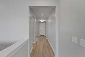 Corridor with light hardwood / wood-style flooring