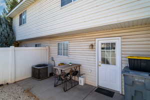 Entrance to property featuring a patio and central air condition unit