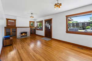 Living room with a healthy amount of sunlight, a chandelier, and hardwood / wood-style floors