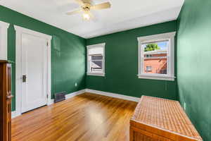 Empty room with hardwood / wood-style floors and ceiling fan