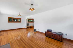 Spare room with a notable chandelier and hardwood / wood-style flooring