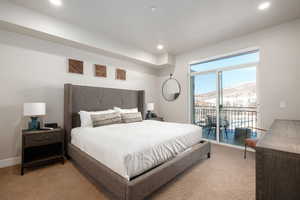 Bedroom featuring a mountain view, light colored carpet, and access to exterior