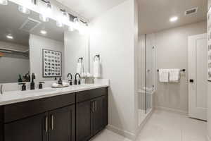 Bathroom with walk in shower, tile patterned floors, and vanity