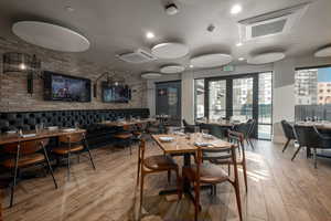 Dining room featuring brick wall and light wood-type flooring