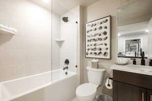 Full bathroom featuring tiled shower / bath, vanity, and toilet