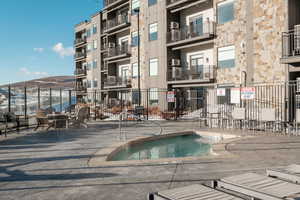 View of pool with a hot tub