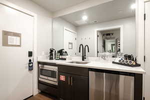 Kitchen featuring stainless steel appliances, dark hardwood / wood-style flooring, sink, and dark brown cabinets