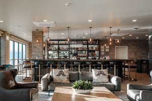 Bar featuring wood-type flooring and brick wall