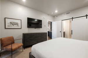 Carpeted bedroom with a barn door