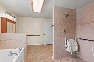 Bathroom featuring tile patterned floors, toilet, and separate shower and tub