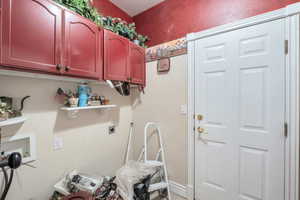 Laundry area featuring electric dryer hookup and cabinets