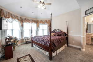 Carpeted bedroom featuring lofted ceiling and ceiling fan