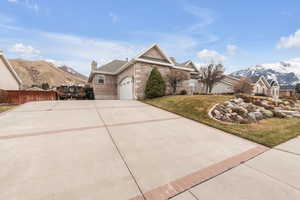 View of front of property featuring a garage, a mountain view, and a front lawn