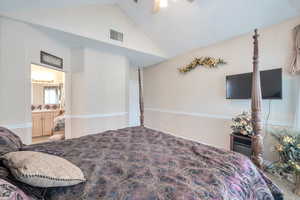 Bedroom featuring vaulted ceiling, ceiling fan, and ensuite bath