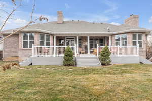 Rear view of house featuring a yard and covered porch