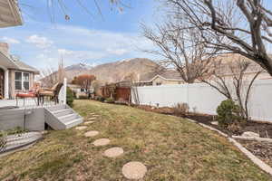 View of yard with a deck with mountain view