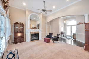 Living room featuring french doors, ornamental molding, carpet flooring, a tile fireplace, and ceiling fan