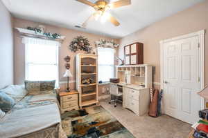 Carpeted office featuring ceiling fan