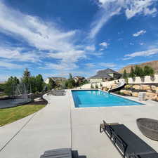 View of pool with a trampoline, a water slide, and a patio