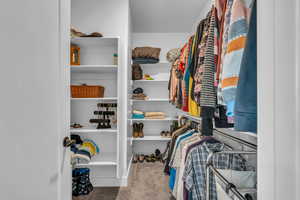 Spacious walk-in closet with carpet floors