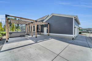 Rear view of property with a hot tub and a pergola